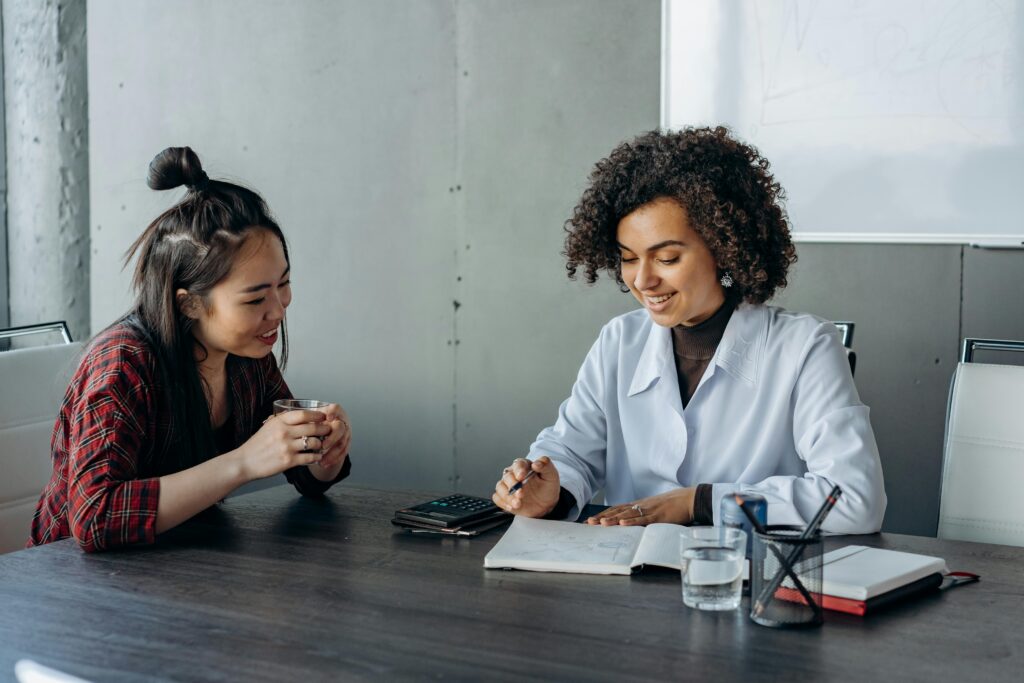 Two women in a modern office setting engaging in a collaborative discussion.